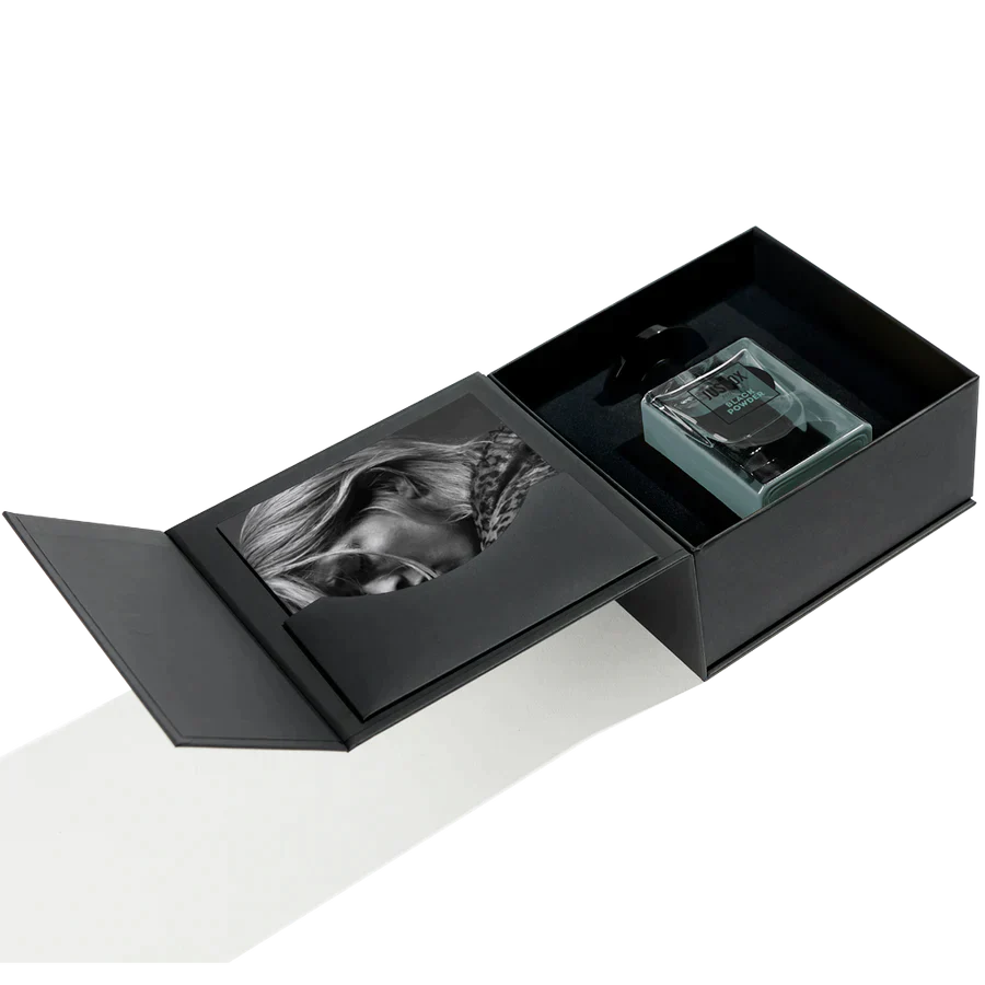 A sleek black gift box with a magnetic lid cradles a black-and-white portrait and a square glass bottle of Jusbox Black Powder Eau de Parfum—an ideal way to showcase this rebellious scent.