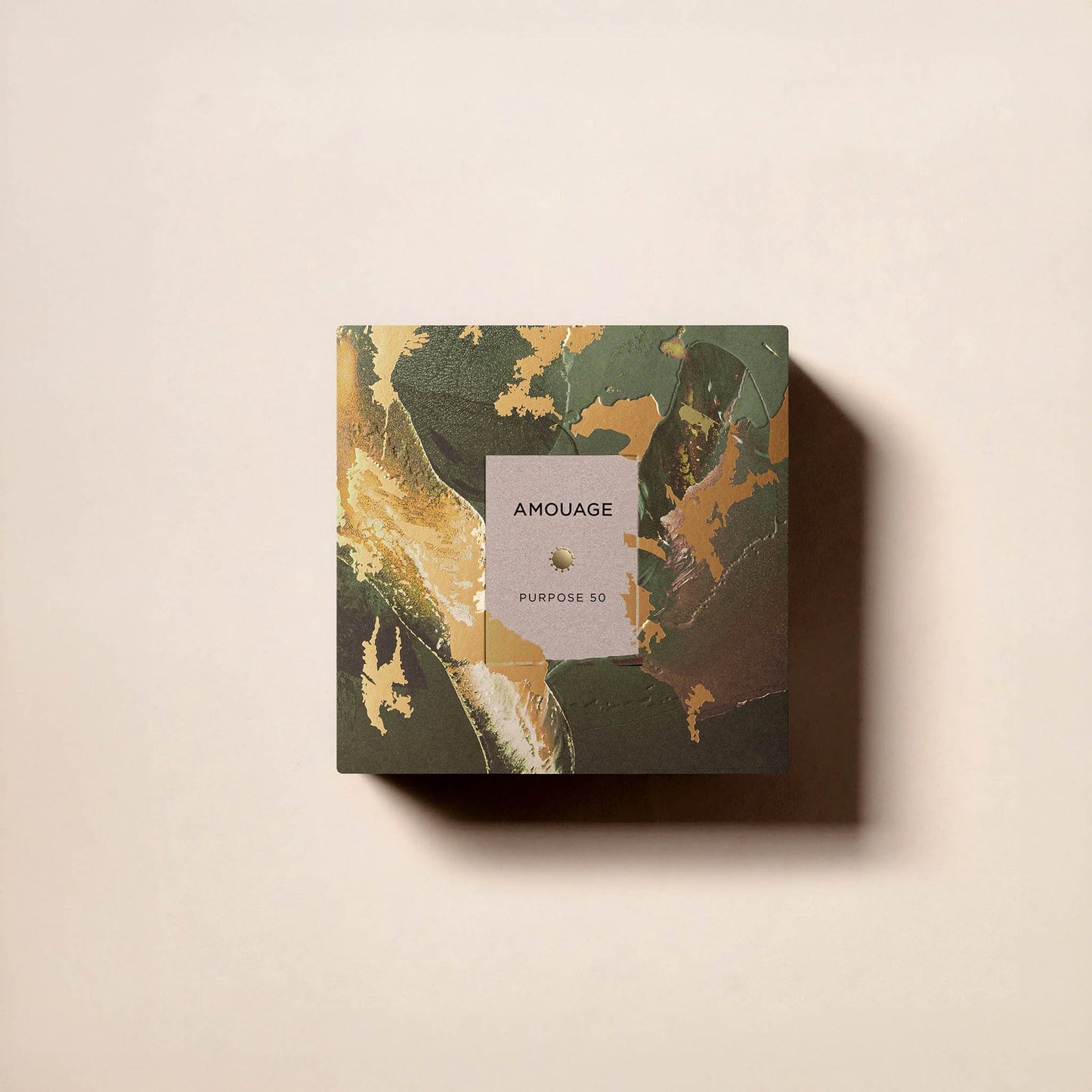 A marbled green, gold, and brown square box labeled Fragrapedia Haus Purpose 50 Extrait de Parfum rests on a light beige surface with a right-cast shadow, reflecting its enduring fragrance.