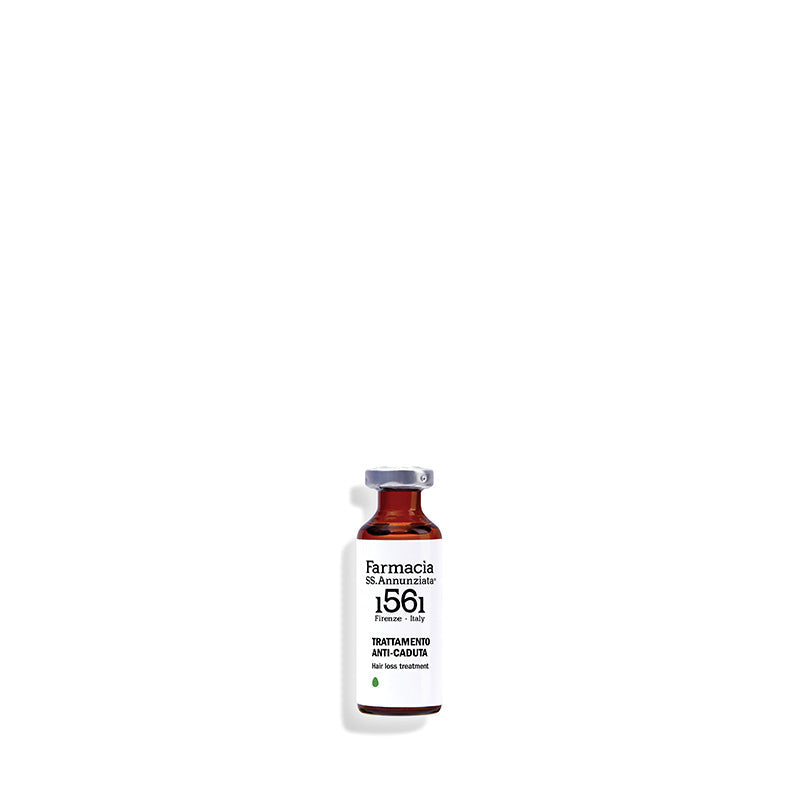 A small glass vial labeled Farmacia SS. Annunziata 1561 Hair loss treatment "TRATTAMENTO ANTI CADUTA" with a silver cap, designed to stimulate hair growth, stands upright on a white background.