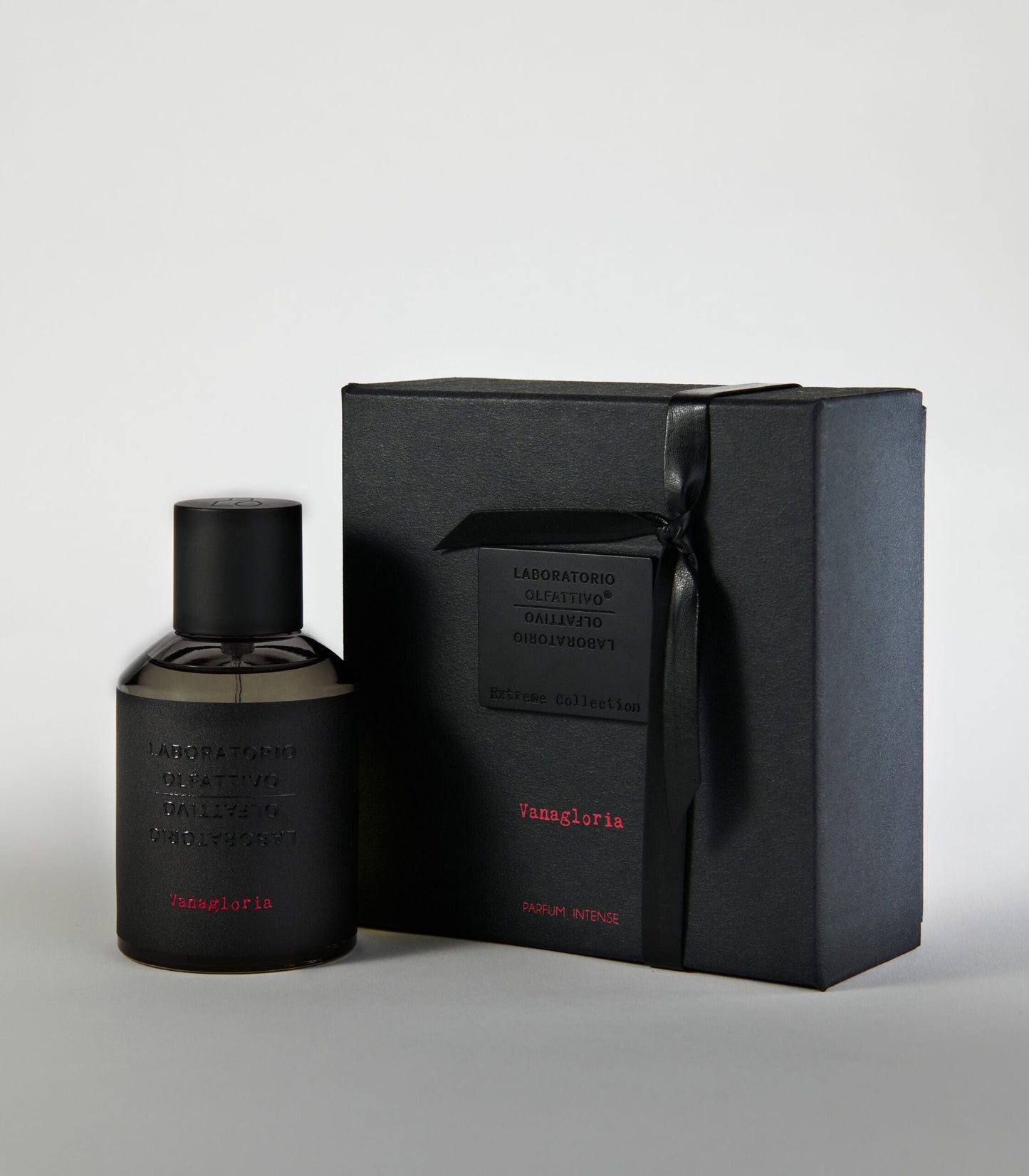 A sleek black bottle of Vanagloria by Laboratorio Olfattivo stands next to a matching gift box with embossed details, both showcasing minimalist design—an elegant display for this sophisticated vanilla fragrance.