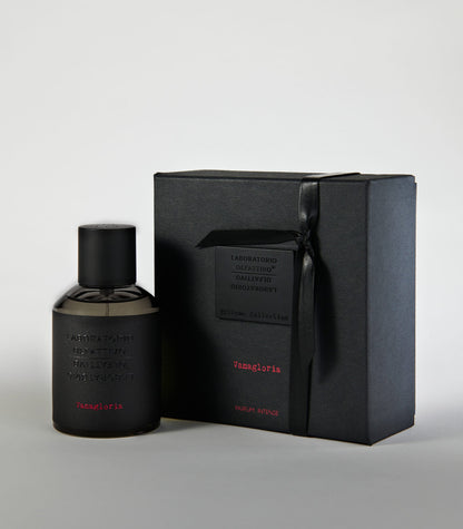 A sleek black bottle of Vanagloria by Laboratorio Olfattivo stands next to a matching gift box with embossed details, both showcasing minimalist design—an elegant display for this sophisticated vanilla fragrance.