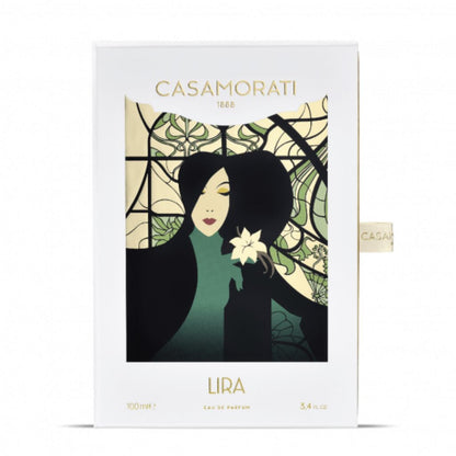 A box for Casamorati 1888 Lira Eau de Parfum by XERJOFF, an oriental vanilla scent, features an Art Nouveau woman with dark hair holding a white flower before a stained glass-style background.