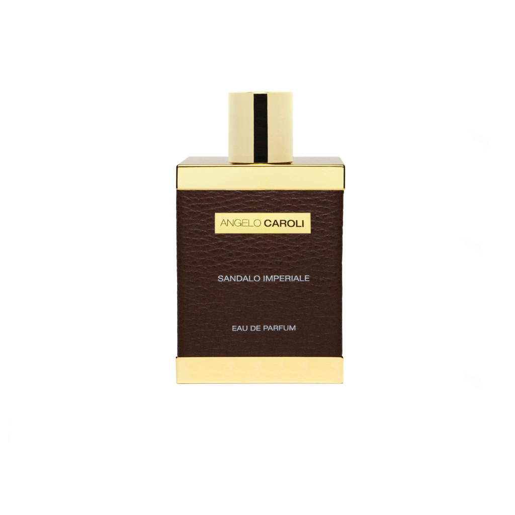 A rectangular perfume bottle with a gold cap and brown leather-textured body, labeled ANGELO CAROLI Sandalo Imperiale Eau de Parfum—a luxurious unisex scent with musk and amber notes.