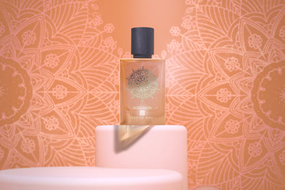 A bottle of SOLOMON Eau de Parfum by Eau De Moe sits on pale pink podiums, featuring a gold mandala design on the 80ML bottle and a matching peach-patterned background.