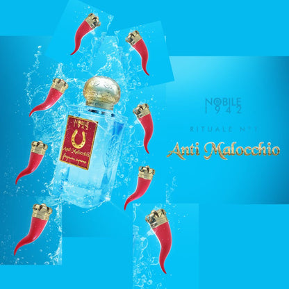 A gold-capped ANTI MALOCCHIO Eau de Parfum by Nobile 1942 is displayed amid scented amulets, red horns, and water splashes on a vivid blue background. Text reads: "Nobile 1942 ANTI MALOCCHIO Eau de Parfum.