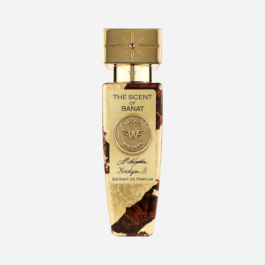 The Scent of Banat Eau de Parfum by Wesker features a gold and brown bottle with ornate detailing, a gold cap adorned with a red gem, embossed front designs, and is crafted with natural ingredients— inspired by Western Banat.