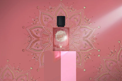 A bottle of Eau De Moe’s CECE Eau de Parfum with a black cap stands on a pink pedestal against a pink backdrop decorated with gold mandala designs, highlighted to showcase the fragrance's elegance and luxury.