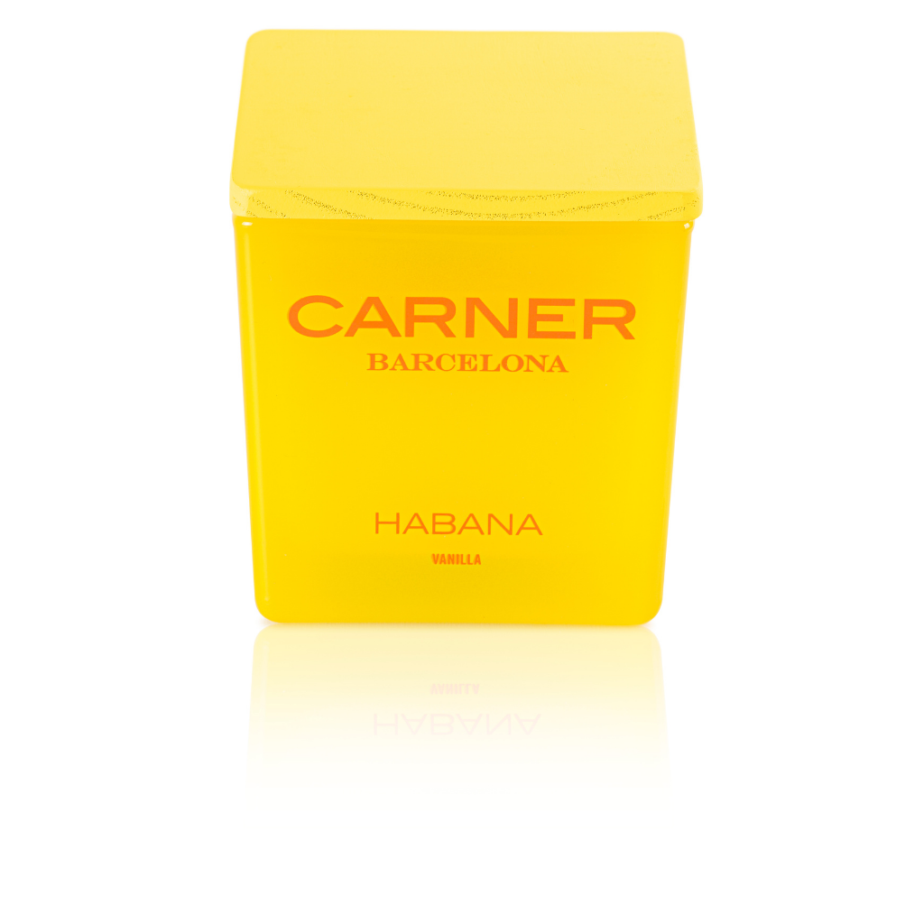 A bright yellow HABANA CANDLE by Carner Barcelona (GIFTS) with a matching square lid and bold red branding sits on a white surface, its label reading "CARNER BARCELONA" and "HABANA VANILLA.
