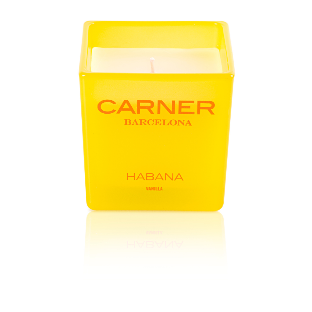 A yellow square GIFTS HABANA CANDLE - Carner Barcelona holder with red branding on the front, featuring a white scented candle and visible wick.