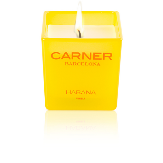 A lit HABANA CANDLE by GIFTS (Carner Barcelona) with a yellow square design flickers brightly against a white background.