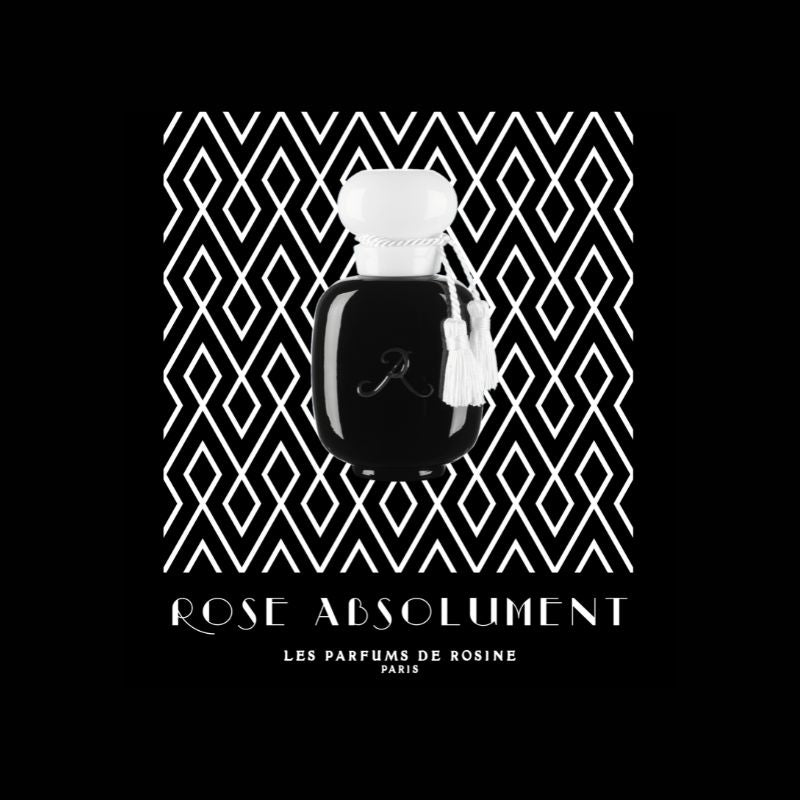 A black perfume bottle with a white cap and tassel, labeled ROSE ABSOLUMENT Eau de Parfum by LES PARFUMS DE ROSINE, sits against a bold black-and-white diamond pattern, capturing the iconic scent’s elegant rose notes.