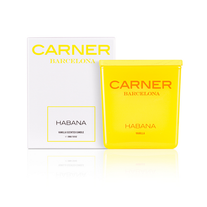 A bright yellow HABANA CANDLE by Carner Barcelona from GIFTS stands before a matching white and yellow box, both featuring the branding and highlighting its vanilla scent.