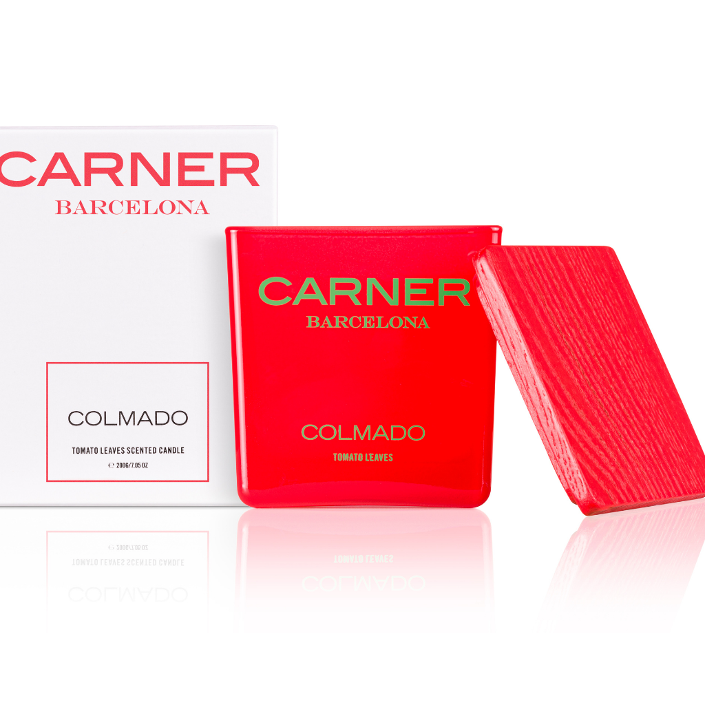A red rectangular COLMADO CANDLE by Carner Barcelona from GIFTS sits beside its textured lid and a white box with red and black text, part of the chic candle collection.