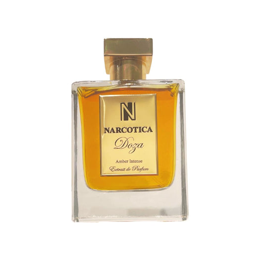 A clear glass bottle of Doza Eau de Parfum by Narcotica with a gold cap and golden-yellow liquid, plus a cream and gold label—an opulent unisex Sweet Amber fragrance highlighted by notes of vanilla beans.