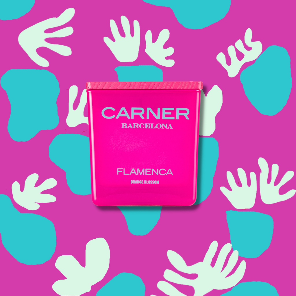 A bright pink FLAMENCA CANDLE by GIFTS sits center stage on a vibrant pink background with scattered blue shapes and white handprints, its label hinting at lively notes of orange blossom and bergamot.