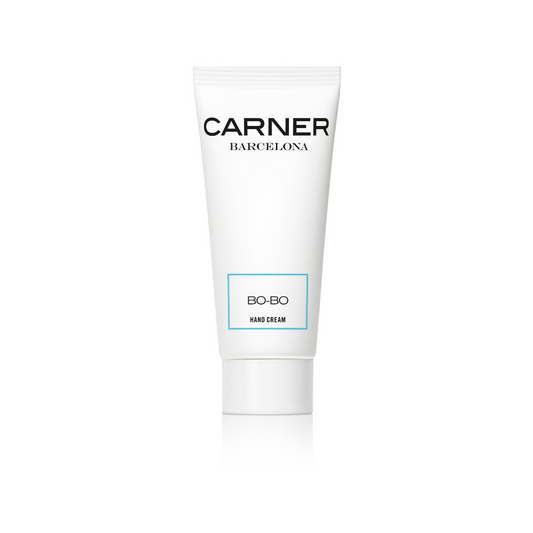 A white tube of GIFTS BO-BO BODY CREAM stands upright against a plain white background. The minimalist packaging, featuring black and light blue text, suggests the moisturizing body cream’s fresh Mediterranean-inspired scent.