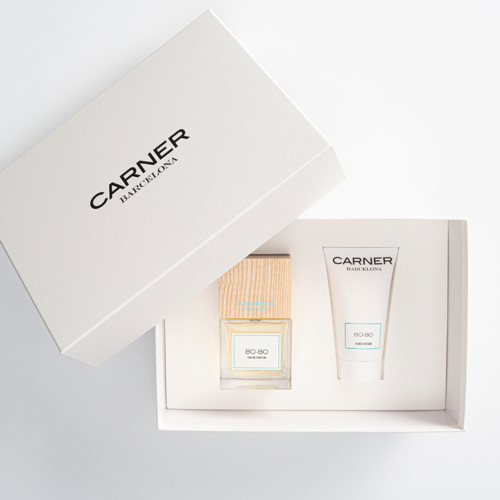 A white GIFTS box displays BO-BO HAND CREAM and Bo-Bo perfume, both neatly placed inside the open box on a white background, evoking the fresh Mediterranean essence.