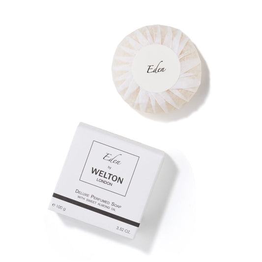 A round, wrapped fragrance soap labeled Eden rests on a box reading EDEN DELUXE PERFUMED SOAP WITH SWEET ALMOND by Welton London, 3.52 oz, made in France, set against a white background.