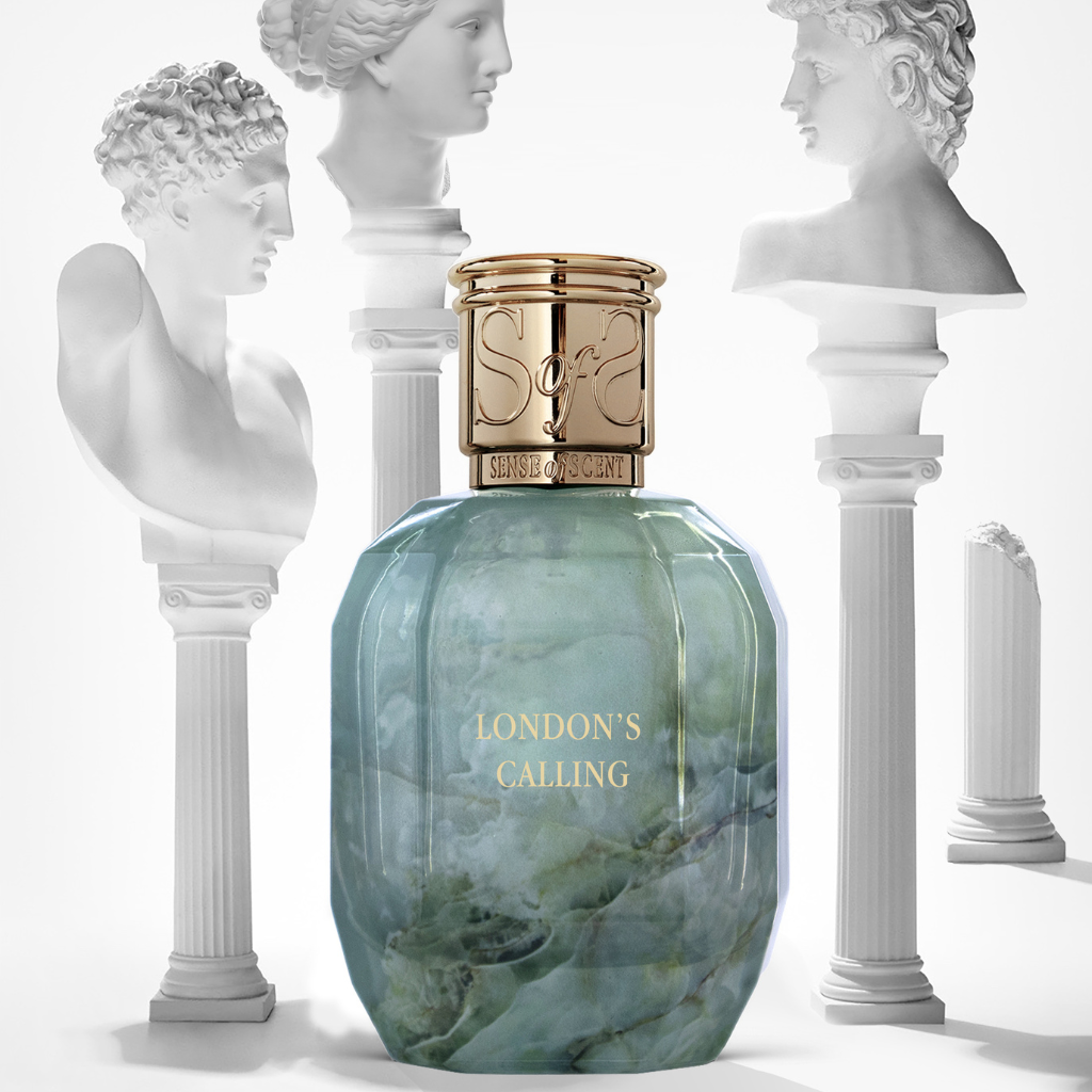 The gold-capped LONDON'S CALLING Eau de Parfum by Sense of Scent, in a marble-patterned bottle, stands before classical white busts and evokes an elegant, artistic ambiance with its exotic Last Orient-inspired fragrance.