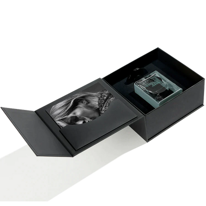 A sleek black gift box with a magnetic lid cradles a black-and-white portrait and a square glass bottle of Jusbox Black Powder Eau de Parfum—an ideal way to showcase this rebellious scent.