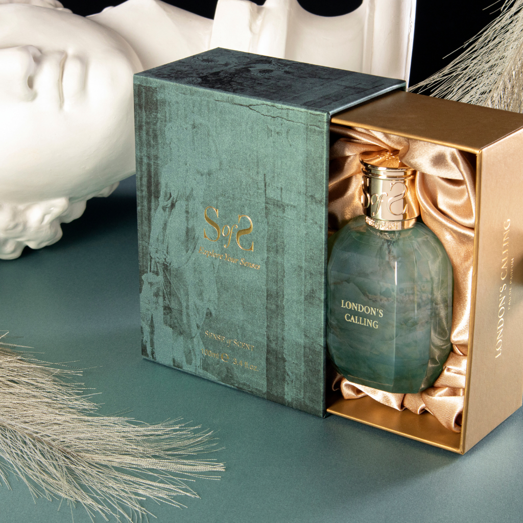 LONDON'S CALLING Eau de Parfum by Sense of Scent is shown in a green and gold box with satin lining, accompanied by decorative accents and a white statue head for an oriental fragrance ambiance.
