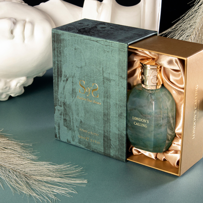 LONDON'S CALLING Eau de Parfum by Sense of Scent is shown in a green and gold box with satin lining, accompanied by decorative accents and a white statue head for an oriental fragrance ambiance.