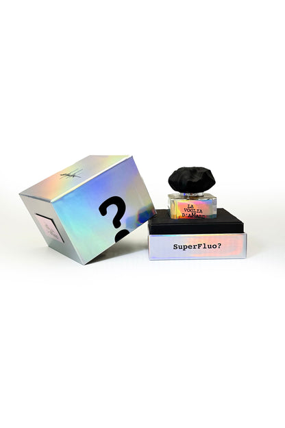 A holographic box with a bold question mark sits beside Filippo Sorcinelli's LA VOGLIA D'AMARE "The Desire To Love" Eau de Parfum, topped with a black cap, on a black base marked SuperFluo?.