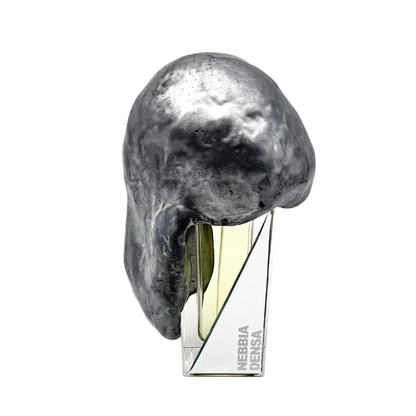 NEBBIA DENSA "dense fog" Eau de Parfum by Filippo Sorcinelli features a geometric clear base labeled NEBBIA DENSA, topped with an irregular metallic cap, evoking earthy vetiver and botanical moss.
