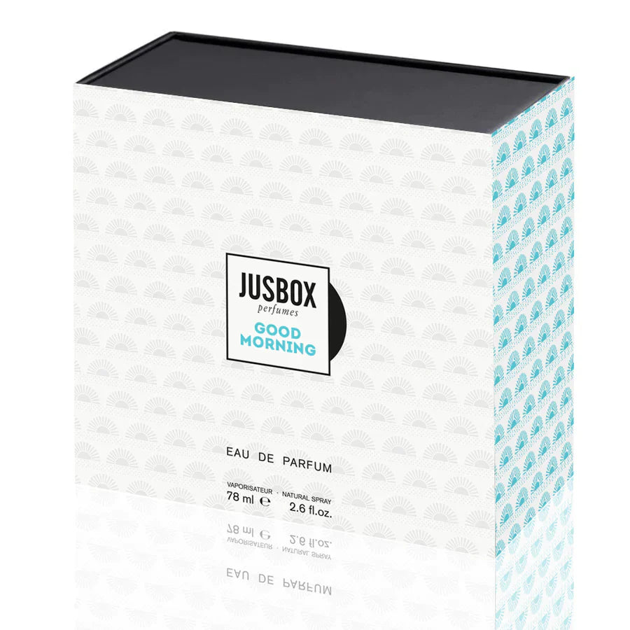 The Good Morning Eau de Parfum - JUSBOX by Jusbox comes in a rectangular box with a white base, teal sunburst pattern, and black lid—reflecting the fragrance’s fresh magnolia and soft musk notes. 78 ml (2.6 fl. oz.).