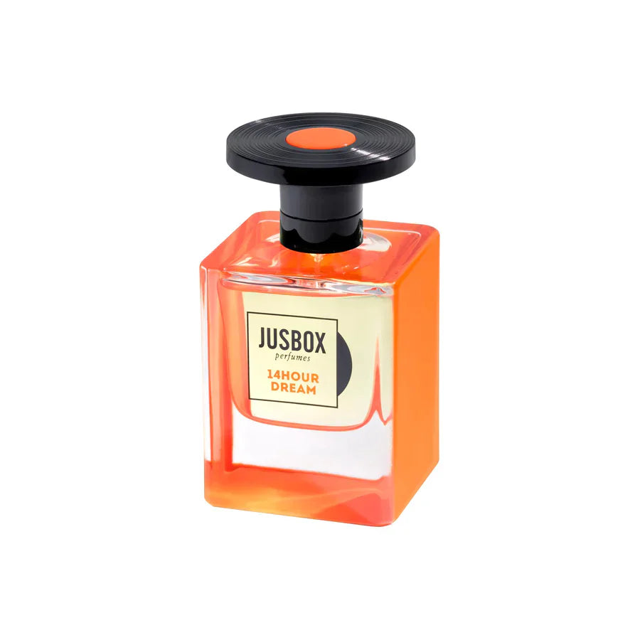 A bottle of Jusbox 14 Hour Dream Eau de Parfum, an oriental fragrance, features a rectangular glass design with orange accents, a black round cap, and a front label displaying the Jusbox brand and fragrance name.