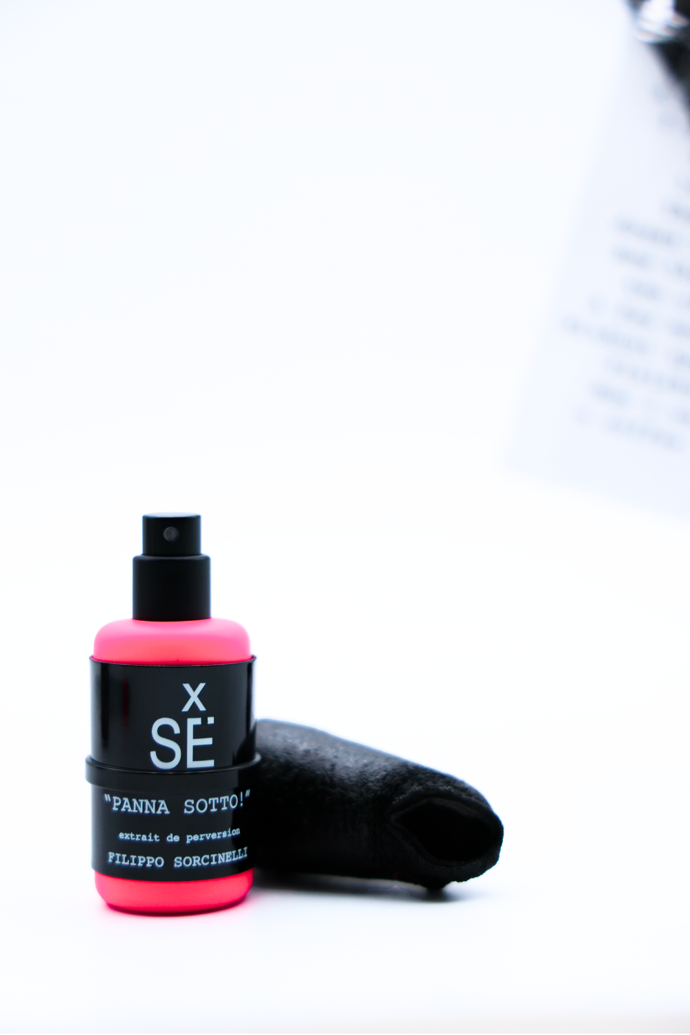 Spray bottle with pink top and black label on a white background