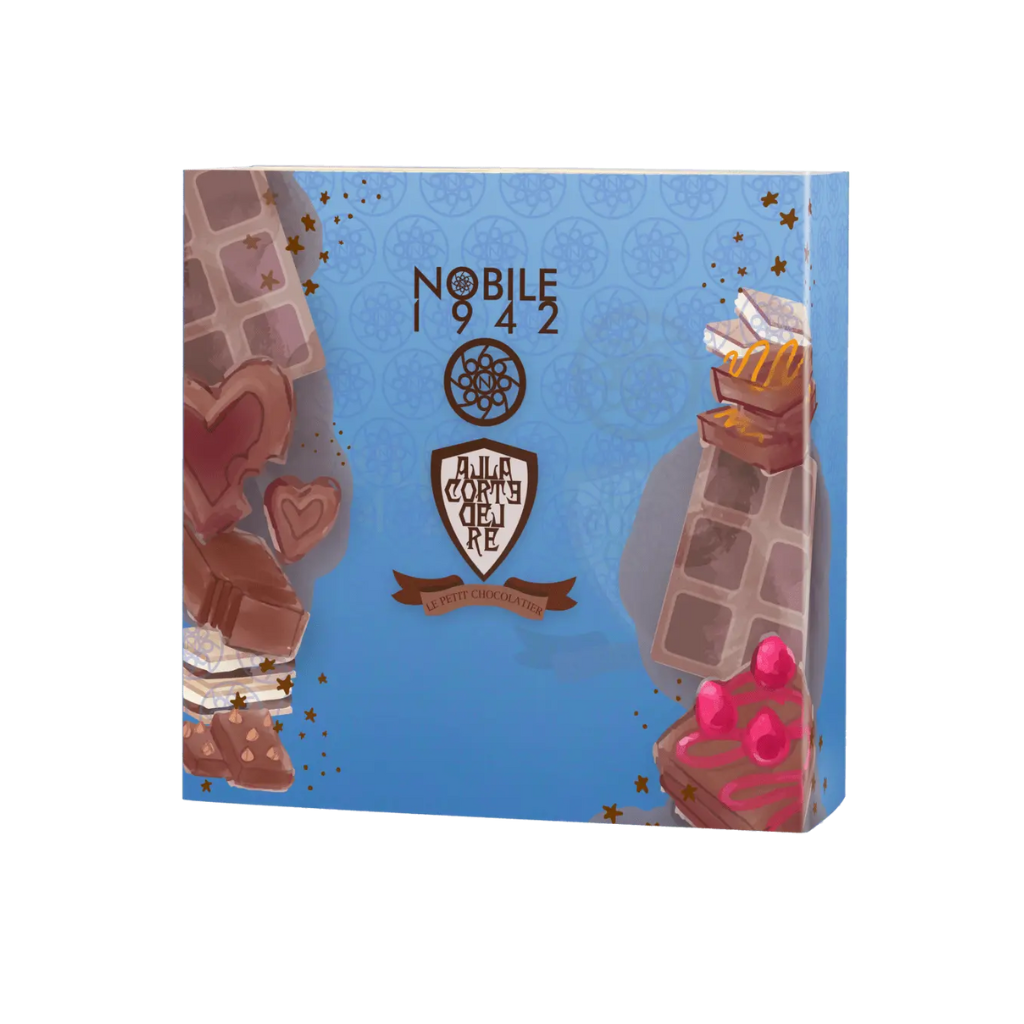 A blue Nobile 1942 box labeled "Le Petit Chocolatier" is adorned with chocolate pieces, hearts, cherries, and a central brown-and-white emblem with a ribbon, evoking its delicious chocolate-inspired fragrance.