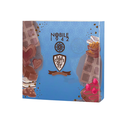 A blue Nobile 1942 box labeled "Le Petit Chocolatier" is adorned with chocolate pieces, hearts, cherries, and a central brown-and-white emblem with a ribbon, evoking its delicious chocolate-inspired fragrance.