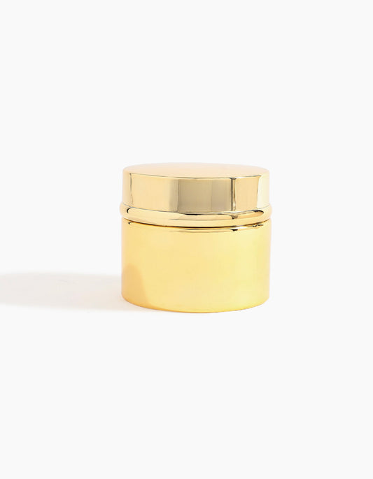 A small, shiny gold-toned cylindrical container with a matching lid, capturing the luxurious essence of Al Shioukh Dokhoon - Hind Al Oud by Hind Al Oud, set against a plain white background.
