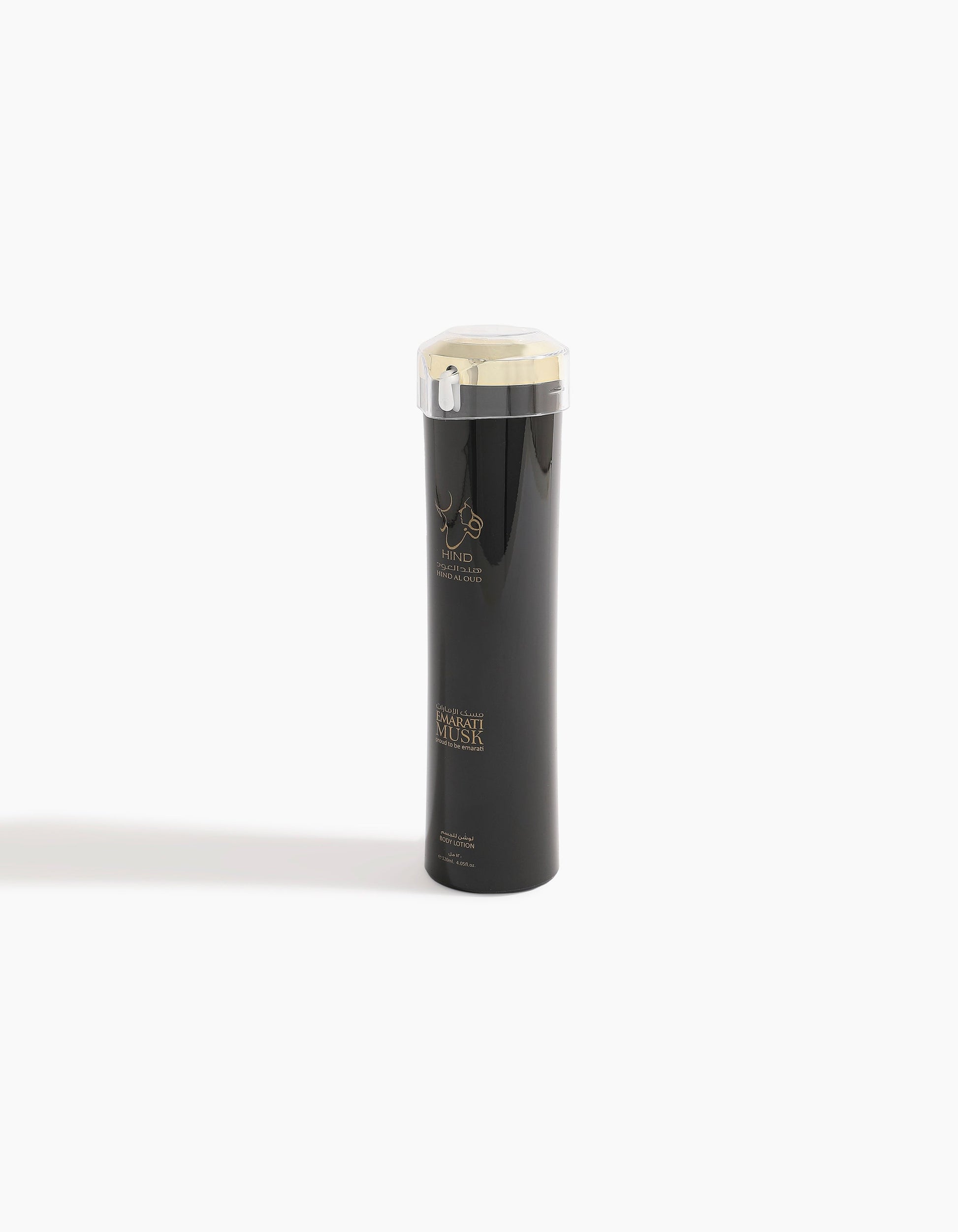 A sleek black bottle with gold accents and a transparent lid, featuring the Hind Al Oud logo and "Emarati Musk Body Lotion" text on the front, stands upright on a white background with a faint shadow to the left.