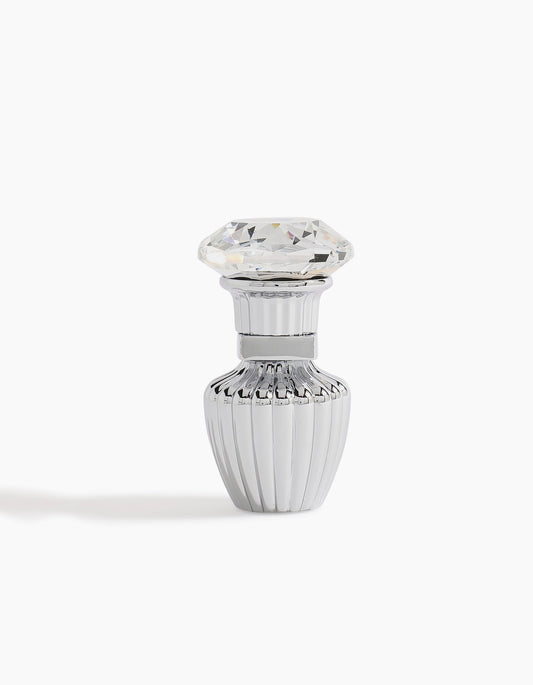 A small, elegant silver Sheikh A Petite Concentrated Oil 3ml bottle by Hind Al Oud, with vertical ridges and a diamond-shaped clear cap, radiates luxury against a white background.