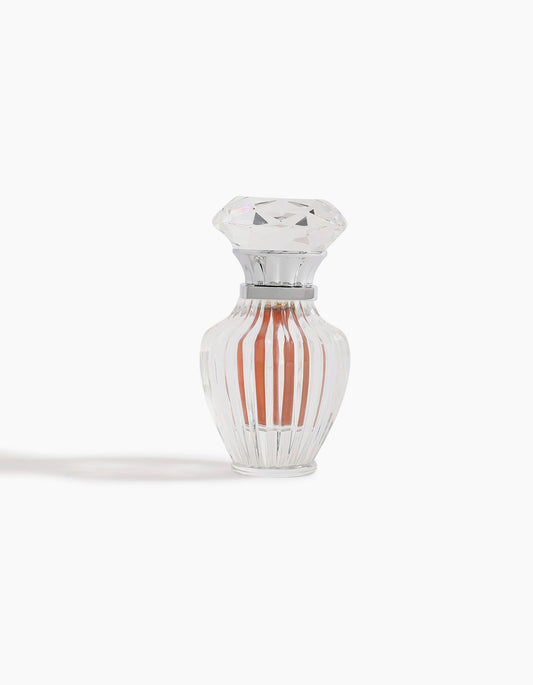 A clear, faceted glass bottle with a diamond-shaped lid holds Sheikh A Jewel Concentrated Oil 6ml by Hind Al Oud, featuring a peach-colored liquid and displayed against a white background.