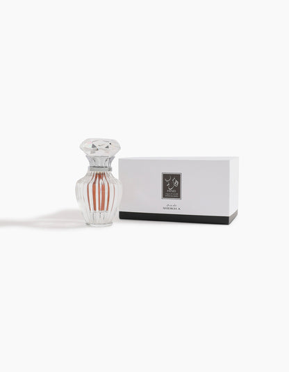 A clear, faceted 6ml Sheikh A Jewel Concentrated Oil bottle by Hind Al Oud with light amber liquid stands next to a white rectangular box featuring a dark label and black base, both displayed against a white background.