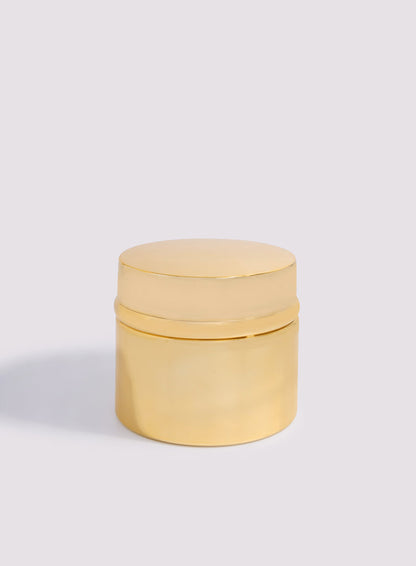 Ahojas Dokhoon by Hind Al Oud: a small, round, shiny gold container with a matching lid, inspired by the luxurious fragrance Ahojas, displayed on a light gray background.