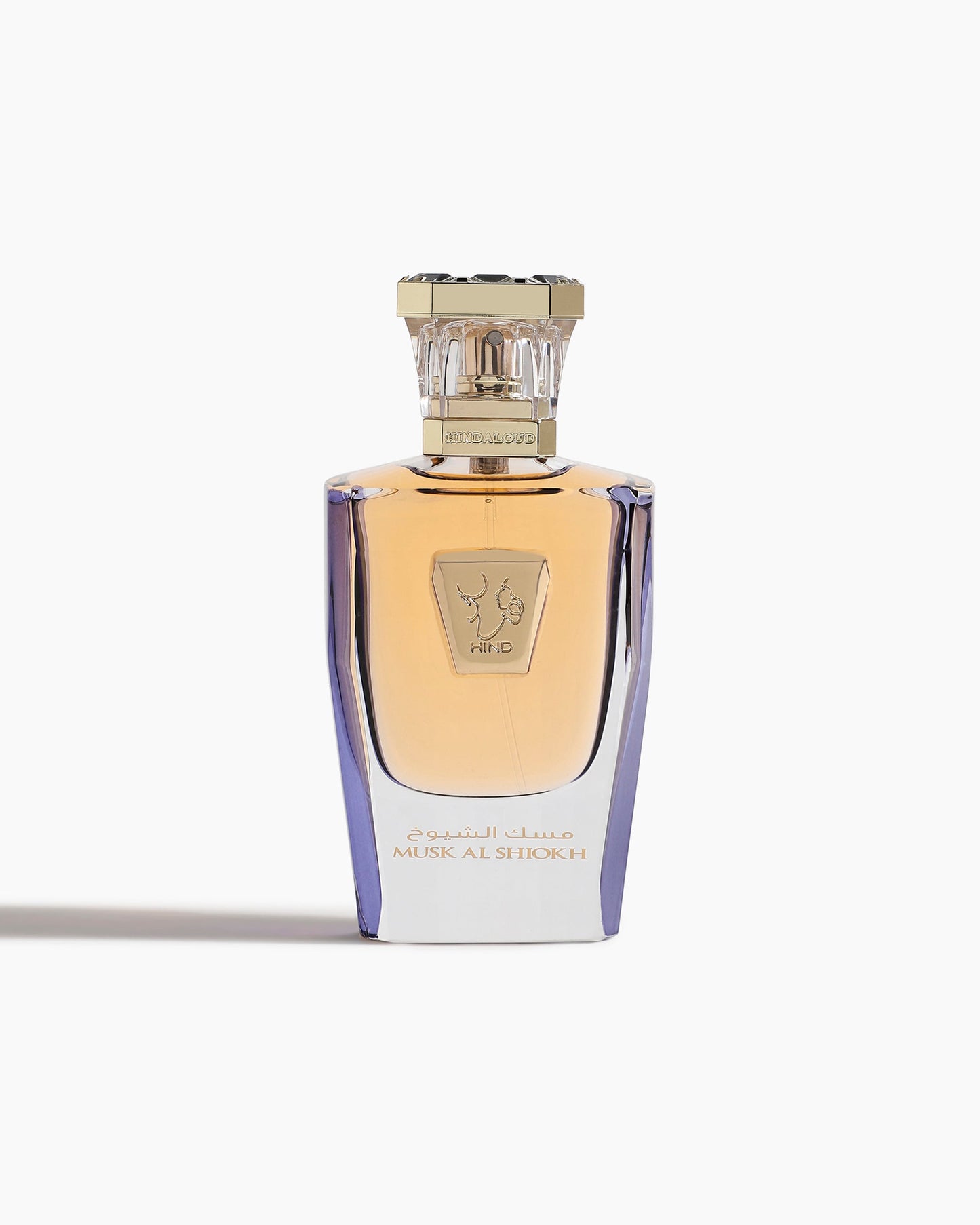 A luxury Musk Al Shiokh Parfum - Hind Al Oud bottle by Hind Al Oud, features gold accents, an ornate clear cap, and Arabic script, reflecting Emarati opulence against a white background.