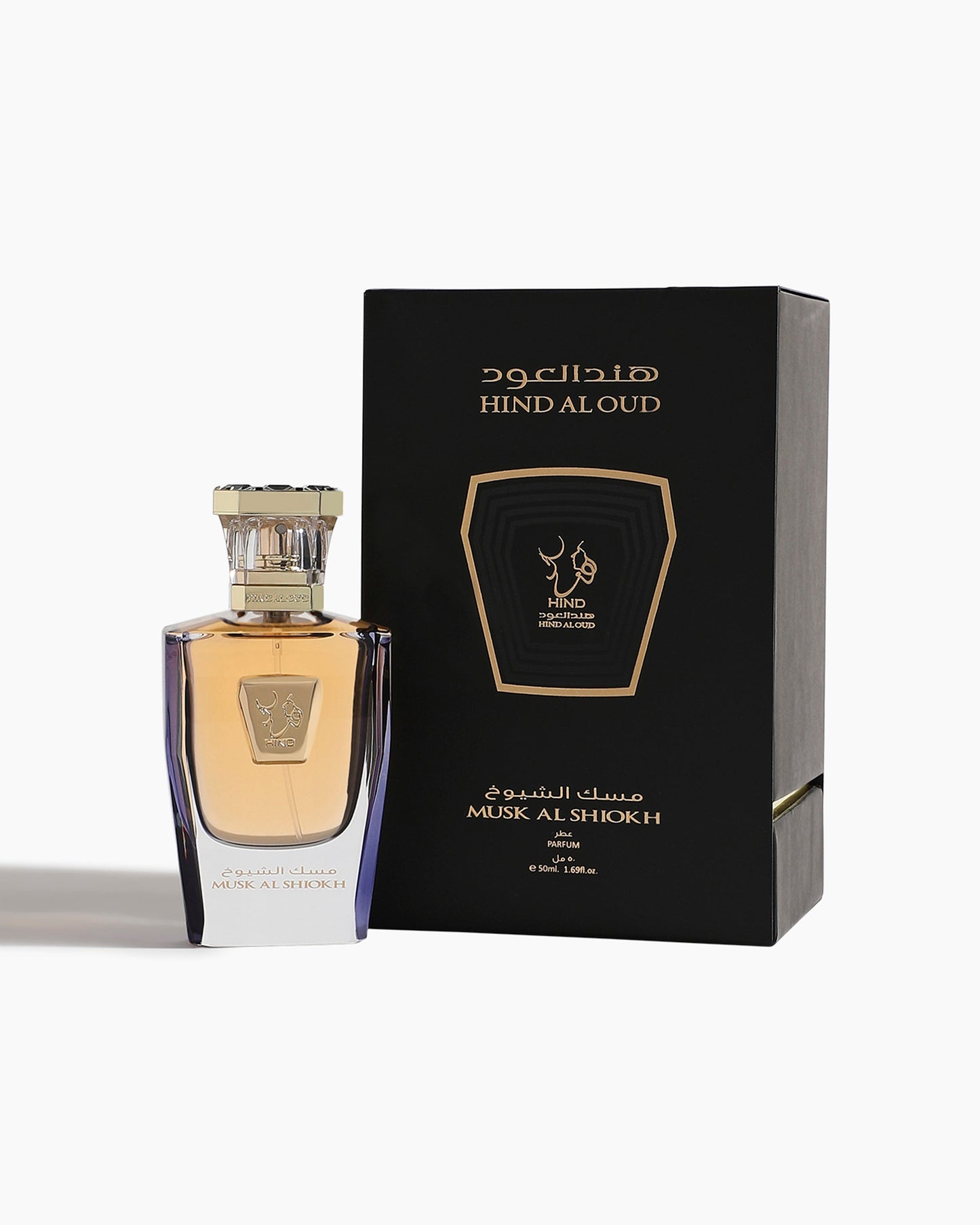A bottle of Musk Al Shiokh Parfum by Hind Al Oud sits beside its black and gold box, adorned with Arabic and English text and a refined logo—showcasing Emarati luxury.