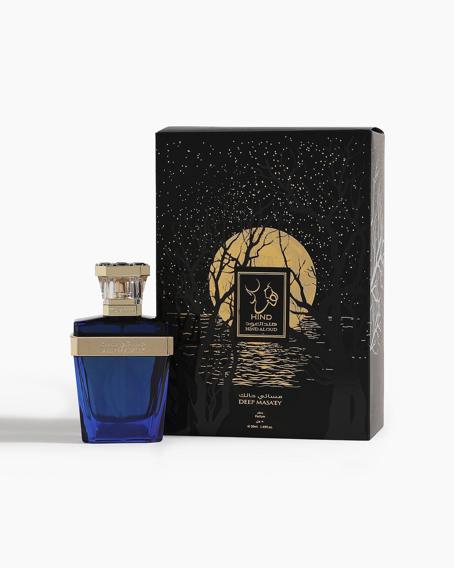 A blue Deep Masa'ey Parfum bottle by Hind Al Oud with a silver cap stands next to a black box featuring a gold moon, starry sky, and trees. The fragrance has notes of nutmeg and cashmere wood, labeled in English and Arabic.