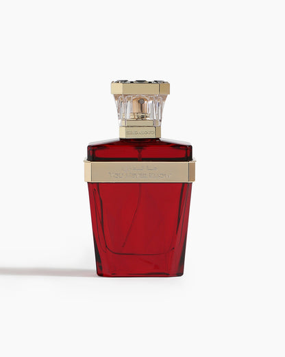 A red glass bottle of You Never Know Parfum by Hind Al Oud, with a gold and clear geometric cap and engraved text, sits against a white background—ideal for Amber Oud lovers.