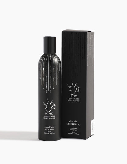 A black bottle of Hind Al Oud Sheikh A Body Spray - Hind Al Oud, with rich agarwood and spices, sits beside its matching black box, both adorned with silver dots and Arabic and English text.