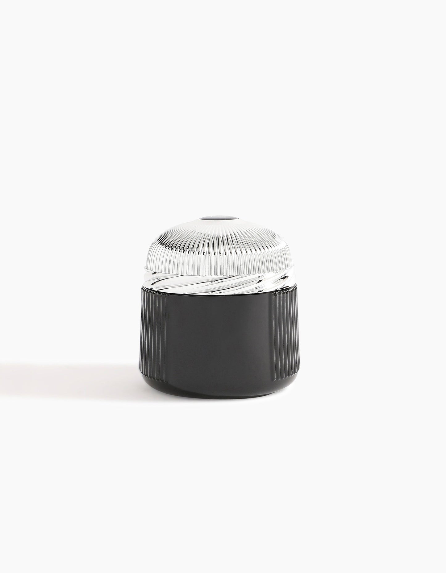The Pink Smoke Oud Muattar by Hind Al Oud is a small, cylindrical black container with a textured silver lid—ideal for storing exotic scents on a simple white background.