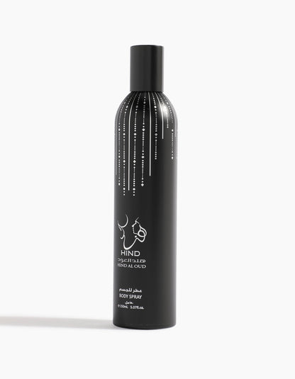 A tall black can of Hind Al Oud Ahojas Body Spray with white Arabic and English text features a decorative pattern of vertical white lines and dots near the top. The scent includes notes of fig, tobacco, and honey.