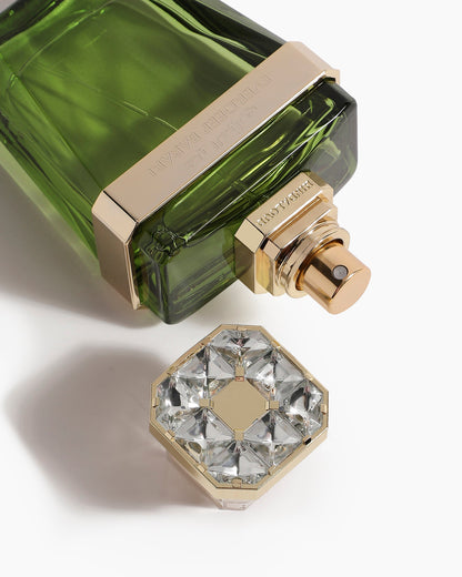 A close-up of the Everdeep Barari Parfum by Hind Al Oud shows its green woody bottle with gold accents, an octagonal cap embellished with clear gemstones, and hints at rich oud and patchouli notes against a white background.