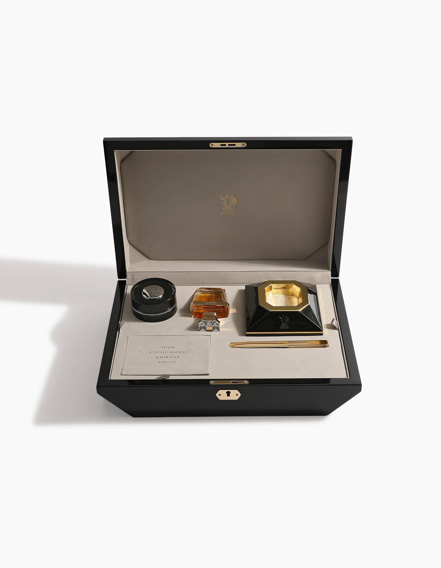 The Diamond Incense Kit Gift Box Option B by Hind Al Oud features a black luxury box with a beige interior, holding a round container, gold and black inkwell, pen, and card—perfectly arranged for an elegant presentation.