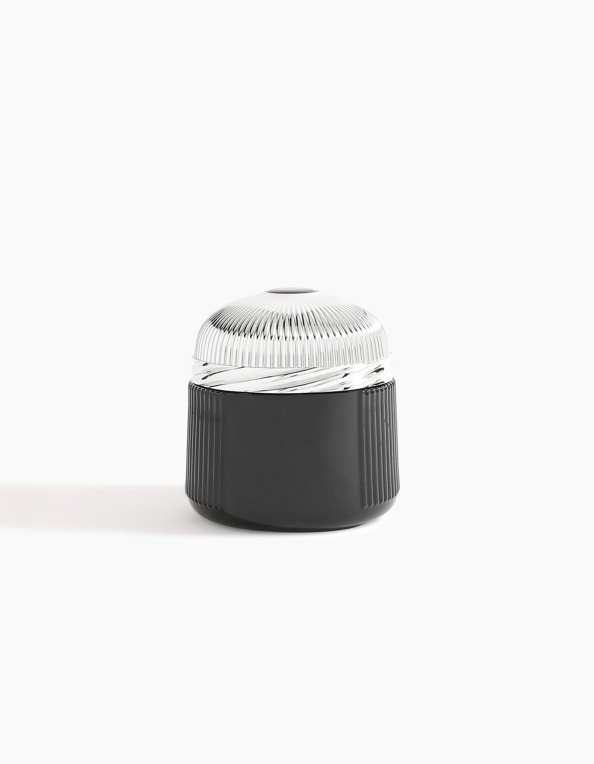 A sleek, cylindrical black container with a ribbed texture and metallic ridged lid, showcased on a white background—reflecting the luxury of Hind Al Oud’s Oud Al Qasr Oud Muattar and its signature woody scent.