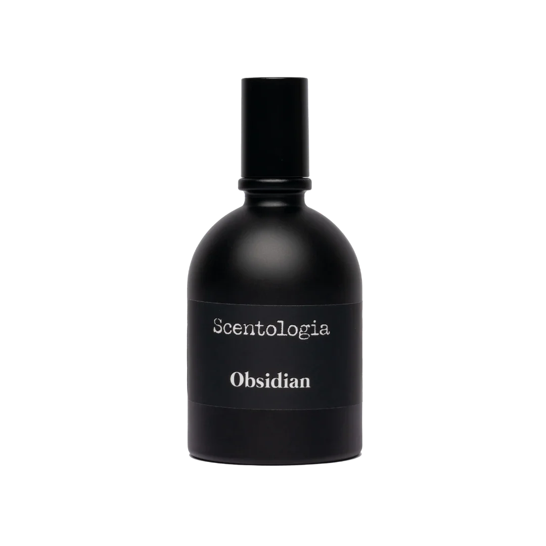 A sleek black bottle of Obsidian Eau de Parfum by Scentologia, featuring a matte finish and white text against a light backdrop, captures an alluring essence and ensures a long-lasting fragrance experience.